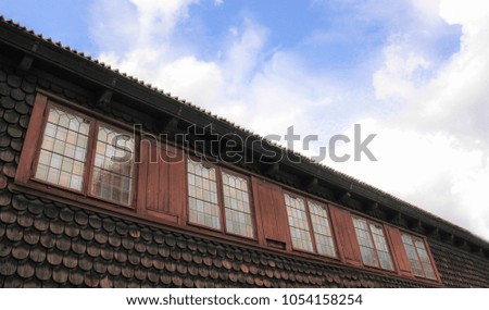 Old wooden building and its beautiful glasses with blue sky and clouds