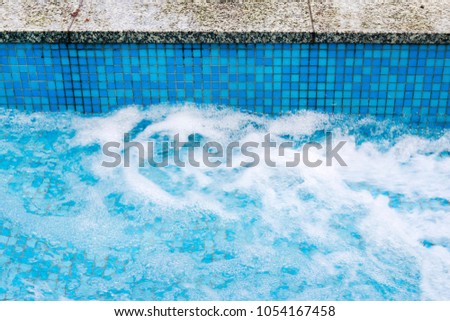 Small waterfall in outdoor pool.