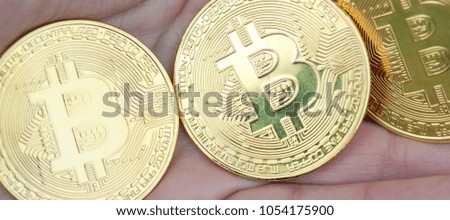 The panorama of female hands hold the three coin on the dark background