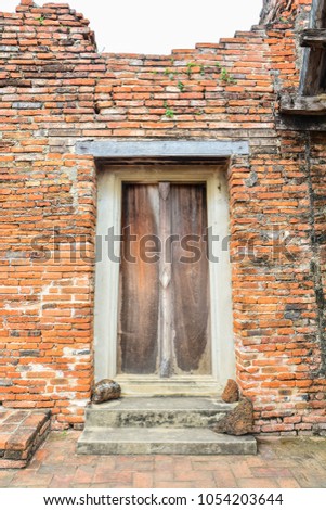 Ancient wooden door in castle wall archaeological site of thailand