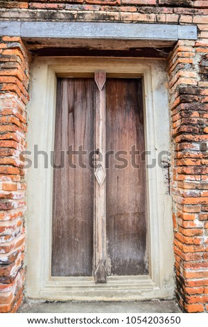 Ancient wooden door in castle wall archaeological site of thailand
