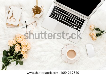 Female workspace with laptop, roses flowers bouquet, golden accessories, notebook, glasses. Flat lay women's office desk. Top view feminine background. Royalty-Free Stock Photo #1054219340