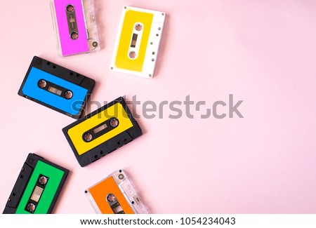 Retro cassette tape collection on pink background, top view, copy space. Royalty-Free Stock Photo #1054234043