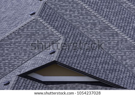 Rooftop in a newly constructed subdivision in Kelowna British Columbia Canada showing asphalt shingles and multiple roof lines Royalty-Free Stock Photo #1054237028