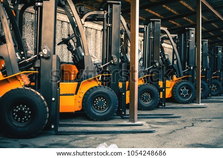 Background of a lot of forklifts, reliable heavy loader, truck. Heavy duty equipment, forklift Royalty-Free Stock Photo #1054248686