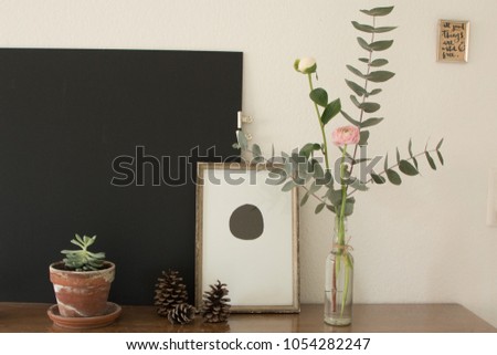 Interior decoration with a big black board and some flowers on an old wooden table, all natural colors. 