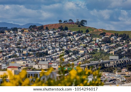San Francisco springtime skyline towards Bernal Heights neighborhood with blooming yellow flowers in the foreground Royalty-Free Stock Photo #1054296017