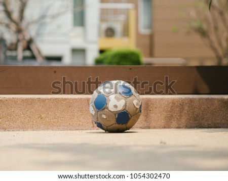 Old and damaged football left on the ground.