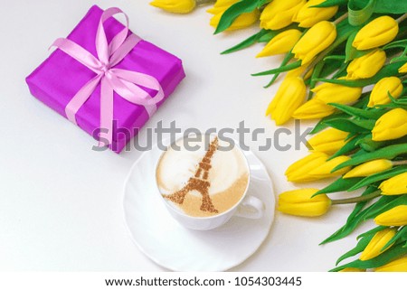 Cappuccino in Paris white cup with yellow tulips and a gift