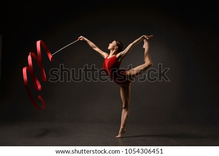 Rhythmic gymnast in red leotard with ribbon