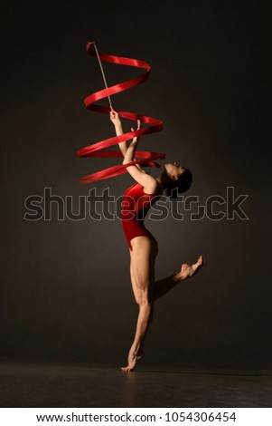 Rhythmic gymnast in red leotard with ribbon