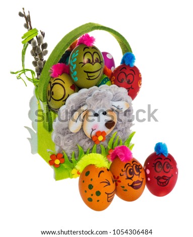 Easter egg, painted in smiling cartoon face of guy. Decorated egg with funny colorful hairstyle and multi-colored patterns sitting in an Easter felt basket. Easter decoration on a white background
