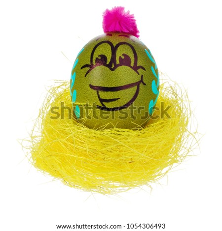 Easter egg, handmade painted in a smiling cartoon face, sit in a yellow bird's nest. Decorated eggs with funny colorful hairstyles and multi-colored patterns. Easter decorations on a white background
