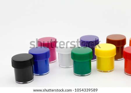 Set of color gouache jars and acrylic paints on white background.