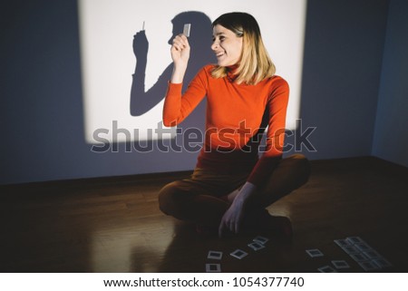Smiling woman looking at photo slides in front of projector screen
