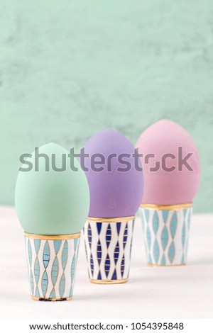 Three Easter eggs of pastel color on retro stands.
