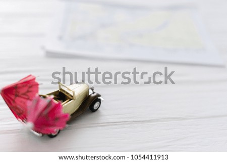 Toy small car on a white wooden background with an umbrella. Concept travel