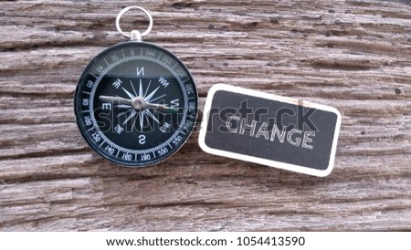 CHANGE inscription written on chalk board, compass on old wooden background

