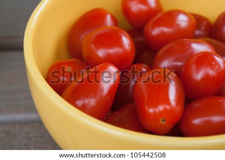 Small cherry tomatoes in yellow bowl