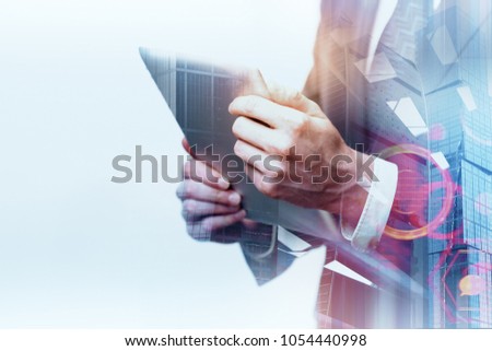 Businessman using tablet on abstract white city background with tech pattern. Technology and communication concept. Double exposure 