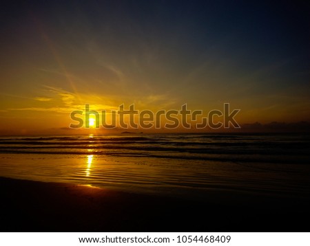 The beautiful golden sunrise, sunshine, sunset on the beach with golden clouds