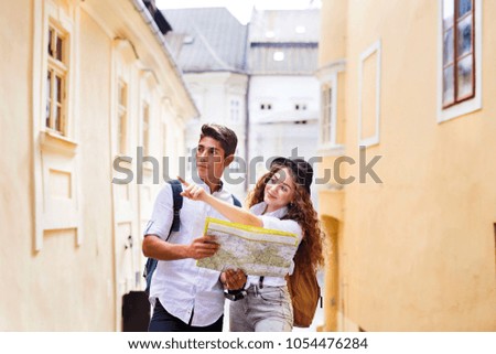 Two young tourists with map and camera in the old town.