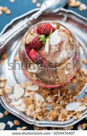 chocolate ice cream glass cup decorated with strawberry scattered muesli harmful food dark background
