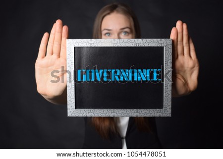 In the hands of a businessman a frame with the inscription:GOVERNANCE