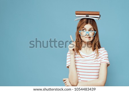schoolgirl holds a notebook on her head                              