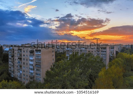 Sky with clouds over city buildings at sunset.
