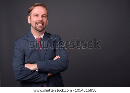 Studio shot of blond bearded businessman with goatee against gray background