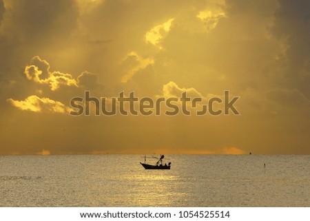 Sihouette picture,Fishing boat in the sea during sunrise