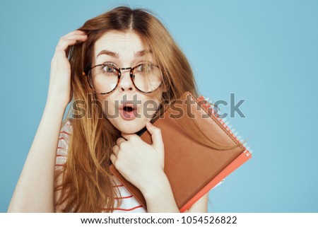 a woman with disheveled hair and glasses with books                         