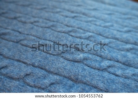 Macro of blue knitted fabric with plaits pattern