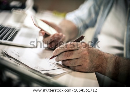 Senior business man writing on document. Close up. Focus is on hand.