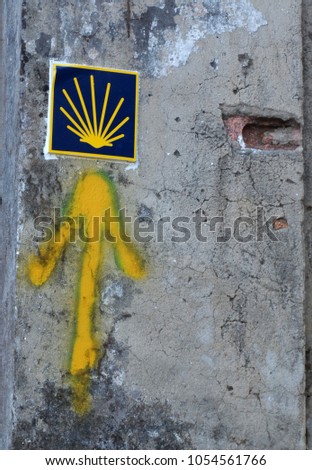 Yellow arrow painted on a wall. Directional sign for pilgrims in Saint james way. Camino de Santiago, Galicia, Spain