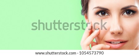 Portrait of beautiful young happy smiling woman, empty copyspace area for slogan or advertising text message, over green background