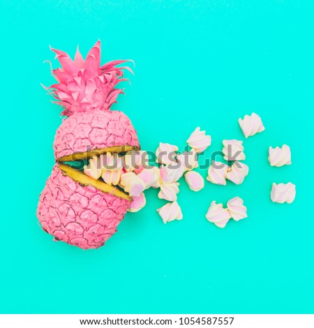 two painted in pink color halfs of the pineapple of which fall marshmallow on turquoise background. fashion minimalism concept of summer food. surreal 