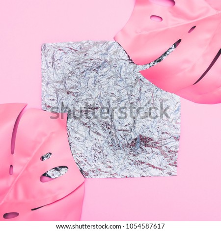 metallic holographic square of foil with empty place for text on pink background with painted tropical palm leaves. fashion minimal and surreal