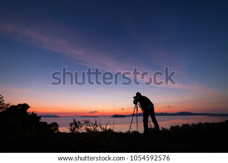 Professional photography man take a photo sunset or sunrise dramatic sky over the tropical sea in phuket thailand