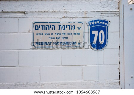 March 2017, Israel, Herzliya - 70 years of the formation of the State of Israel, the symbols and the name of the street on the white wall Royalty-Free Stock Photo #1054608587