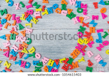 multicolored wooden letters on a gray wooden background with a clean middle, day of knowledge