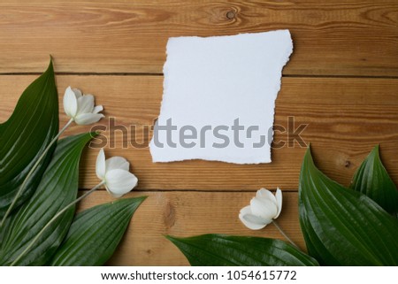 gift with flowers on a wooden background, there is free space for text, a festive flat layer