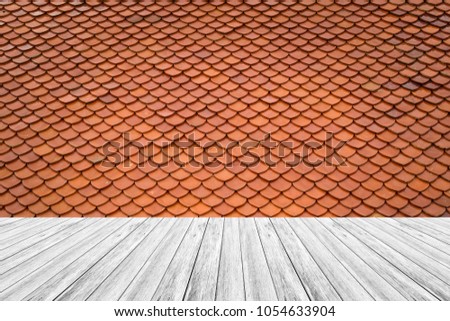 Tile roof of old Thai temple texture background surface natural color with wood terrace