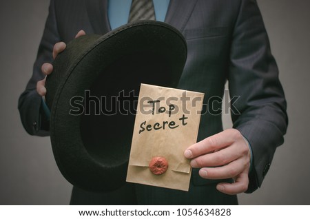 Top secret concept. Open the secret. Business man takes out secret documents from his hat. Confidential dossier information. Super important information. Royalty-Free Stock Photo #1054634828