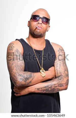 Hip hop urban gangster black man wearing dark shirt and golden jewelry isolated on white. Smoking cigarette. Looking confident. Cool guy. Studio shot.