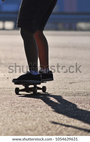 young girl with shorts riding on his skateboard on the road 