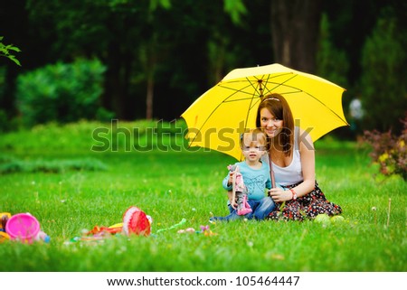 Happy family outdoors on the grass in a park, smiling faces all lying down having fun