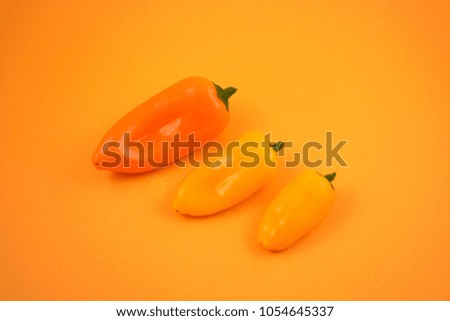 Orange peppers stock images. Orange peppers on a orange background. Group of peppers