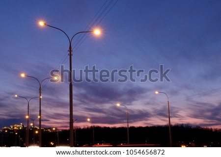 city lighting poles off the road, evening landscape Royalty-Free Stock Photo #1054656872